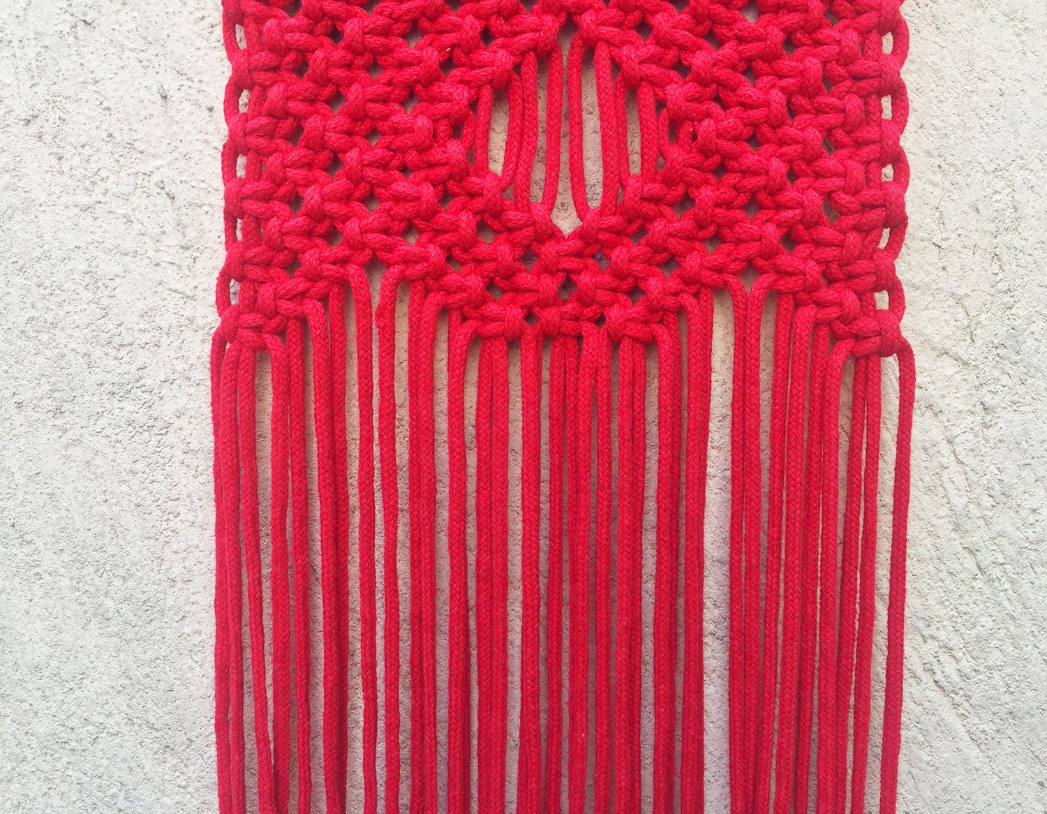 Detalle de tapiz de macramé rojo